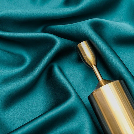 Petrolgrön mörkläggningsgardin med blommönster.