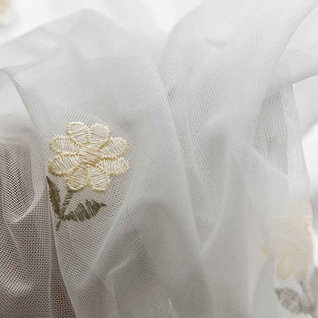 Vit tunn gardin med små blommor