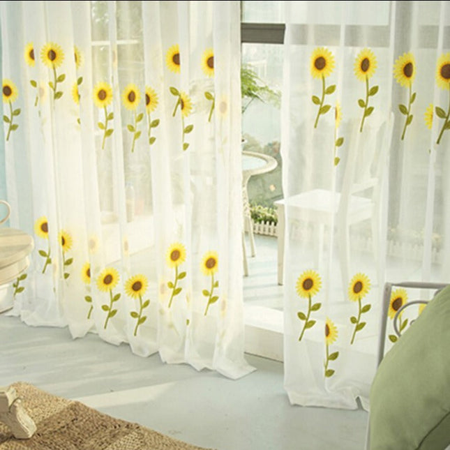 Tunn gardin med broderade solrosor