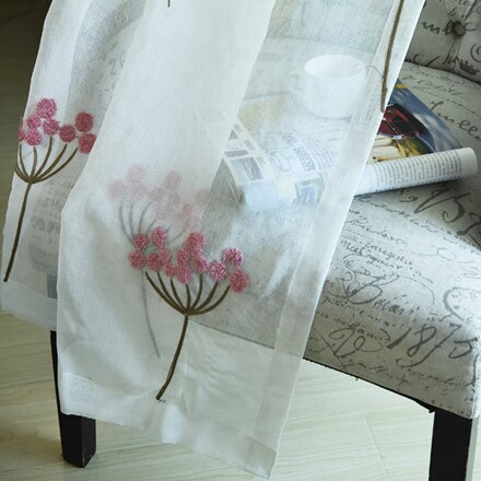 Tunn gardin med dammrosa broderade blommor