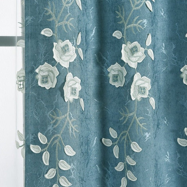 Blå gardin med vita broderade blommor