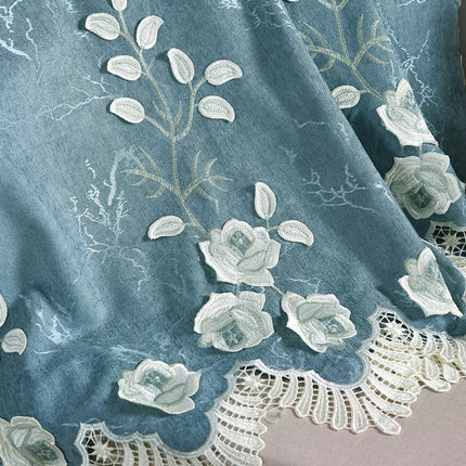Blå gardin med vita broderade blommor