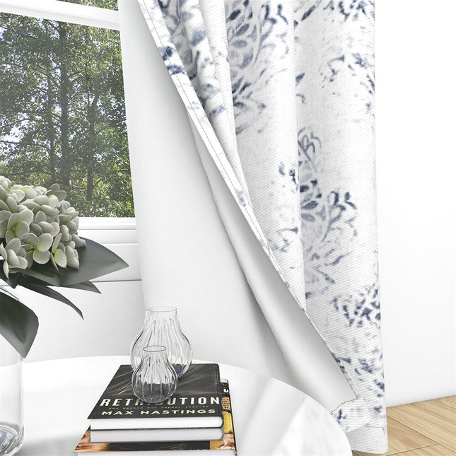 Ljus gardin med elegant blått mönster.