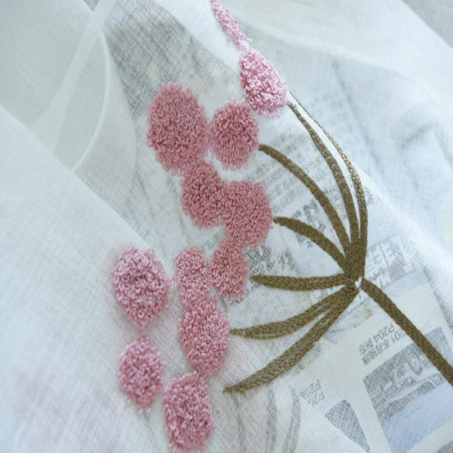 Tunn gardin med dammrosa broderade blommor