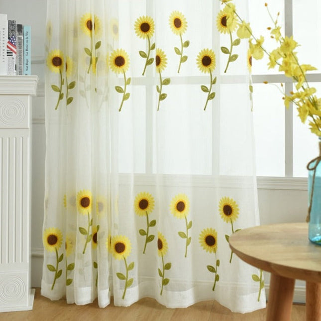 Tunn gardin med broderade solrosor