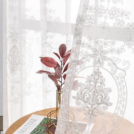 Vit spetsgardin med klassiskt mönster