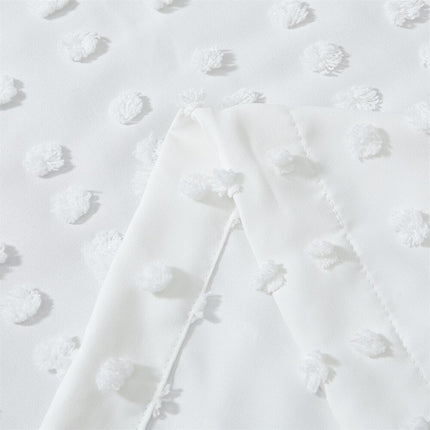 Vit gardin med vävd pom-pom-textur