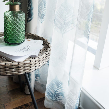 Tunn gardin med blått lövmönster