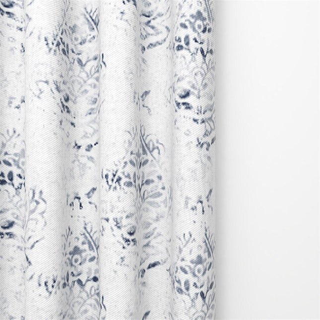 Ljus gardin med elegant blått mönster.