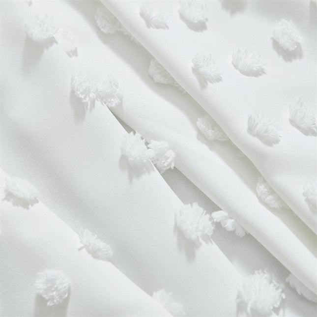 Vit gardin med vävd pom-pom-textur