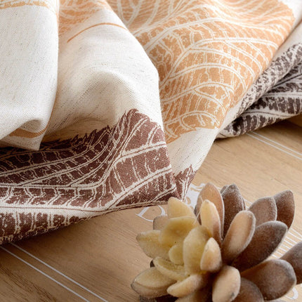 Gardin med stort lövmönster i jordnära färger