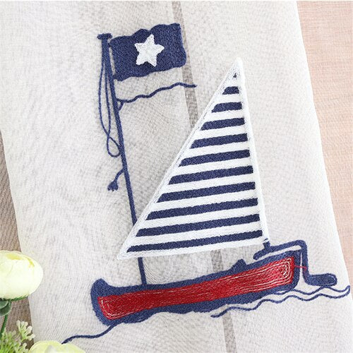 Tunn gardin med broderad segelbåt