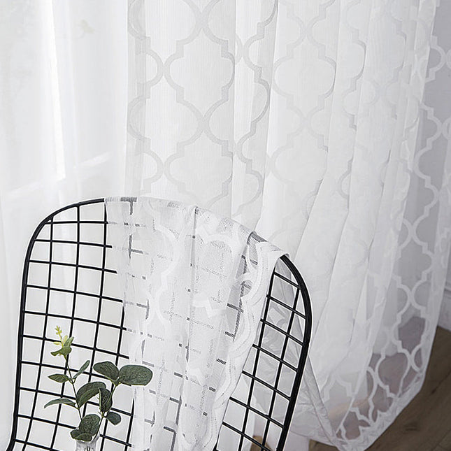 Vit voilegardin med geometriskt mönster