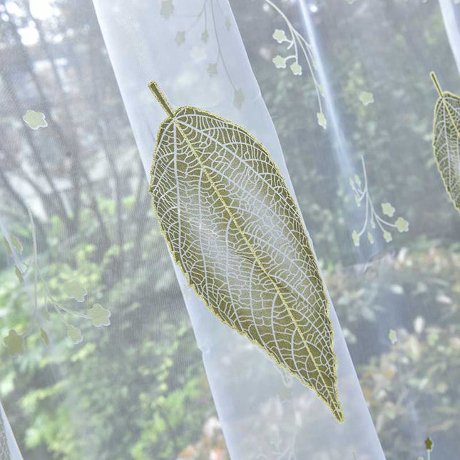 Tunn gardin med grönt lövmönster